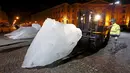 Petugas saat menurunkan balok es untuk ipetunjukkan ke warga Paris yang ada di Place du Pantheon, Perancis, Kamis (3/12). Balok es ini diambil langsung dari daerah Greenland. (REUTERS/Benoit Tessier)