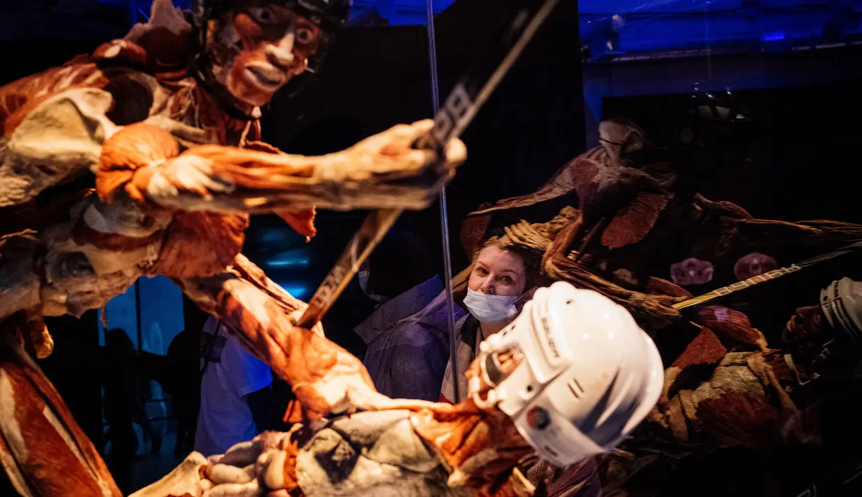 Pengunjung melihat salah satu karya seni yang dipajang dalam pameran anatomi tubuh manusia bertajuk 'Body Worlds' di Moskow, Rusia (24/3/2021). Pameran ini menjadi polemik dan menuai banyak kecaman lantaran menggunakan mayat manusia. (AFP/Dimitar Dilkoff)