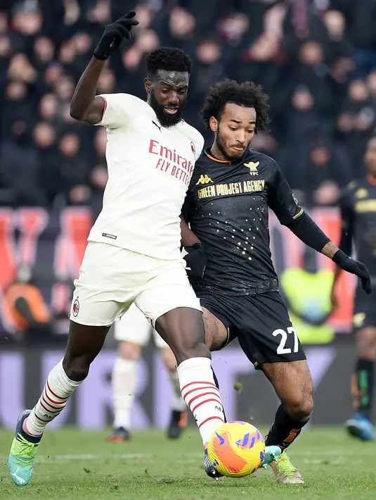 Gelandang AC Milan, Tiemoue Bakayoko (kiri) berebut bola dengan penyerang Venezia, Gianluca Busio pada pertandingan lanjutan Liga Serie A Italia di stadion Penzo, Venesia, Italia, Minggu (9/1/2022). AC Milan menang atas Venezia 3-0. (AFP/Marco Bertorello)