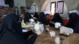 Wanita Palestina membuat boneka domba  menjelang Idul Adha, di desa Badui "Umm Al-Nasr" di Jalur Gaza utara (14/7/2021). Idula Adha merupakan sebuah Hari Raya Islam yang akan di rayakan seluruh umat Islam dunia  pada 20 Juli 2021. (AFP/Mohammed Abed)