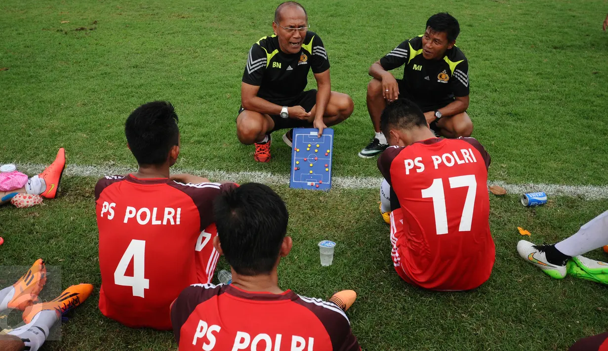 Pelatih PS Polri, Bambang Nurdiansyah (tengah) memberi arahan pada pemainnya saat jeda laga melawan PS MSG di Mako Brimob, Depok, Rabu (24/2/2016). Laga persiapan turnamen Piala Bhayangkara 2016 ini berakhir imbang 1-1. (Liputan6.com/Helmi Fithriansyah)