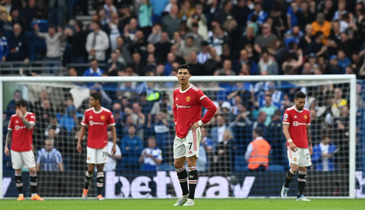 <p>Reaksi pemain Manchester United Cristiano Ronaldo (kedua kanan) dan rekan satu timnya saat pemain Brighton and Hove Albion mencetak gol ke gawang mereka pada pertandingan sepak bola Liga Inggris di American Express Community Stadium, Brighton, Inggris, 7 Mei 2022 . Manchester United kalah 0-4. (Glyn KIRK/AFP)</p>