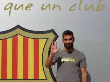 Pemain baru Barcelona, Arda Turan menyapa awak media saat sesi perkenalan di luar Stadion Camp Nou, Barcelona, Spanyol, (9/7/2015). Barcelona resmi mendatangkan eks bintang Atletico Madrid dengan nilai kontrak mencapai 41 juta Euro. (AFP PHOTO/Lluis GENE)