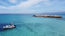 Sebuah perahu terlihat dari pemandangan udara di Akamas di sepanjang pantai barat Siprus (31/5/2020). Semenanjung ini dinamai setelah putra Theseus, pahlawan Perang Troya dan pendiri kerajaan kota Soli. (AFP Photo/Etienne Torbey)