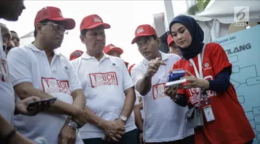 Menteri Perhubungan Budi Karya Sumadi, Menpan-RB Asman Abnur melihat simulasi pembayaran E-Tilang di Jakarta, Minggu (4/3). Layanan tersebut diharapkan dapat memudahkan masyarakat mengurus administrasi tilang. (Liputan6.com/Faizal Fanani)