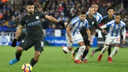Penyerang Manchester City, Sergio Aguero (kiri) mencetak satu gol lewati titik putih saat melawan Huddersfield Town pada laga Premier League di John Smith's stadium, Huddersfield, (26/11/2017).  City menang 2-1. (AFP/Oli Scarff)