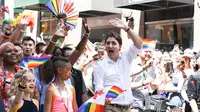 Perdana Menteri Kanada Justin Trudeau menyapa warga saat mengikuti pawai LGBT Toronto's Pride Parade di Toronto, Kanada, Minggu (23/6/2019). Pawai digelar untuk mengenang peristiwa Stonewall yang terjadi di New York pada Juni 1969. (George Pimentel/GETTY IMAGES NORTH AMERICA/AFP)