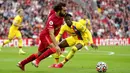 Pemain Liverpool Mohamed Salah berlari dengan bola yang disaksikan oleh pemain Crystal Palace Wilfried Zaha (kanan) pada pertandingan Liga Inggris di Stadion Anfield, Liverpool, Inggris, Sabtu (18/9/2021). Liverpool menang telak 3-0. (AP Photo/Jon Super)