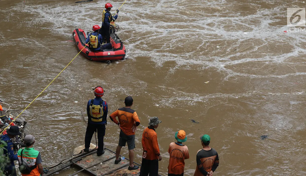 Petugas SAR dari unsur Damkar PB bersama petugas PPSU melakukan operasi pencarian di Kalibaru, Jakarta, Kamis (20/12). Operasi pencarian terkait informasi adanya orang tenggelam di Kalibaru, Pasar Rebo, Jakarta Timur. (Liputan6.com/Helmi Fithriansyah)