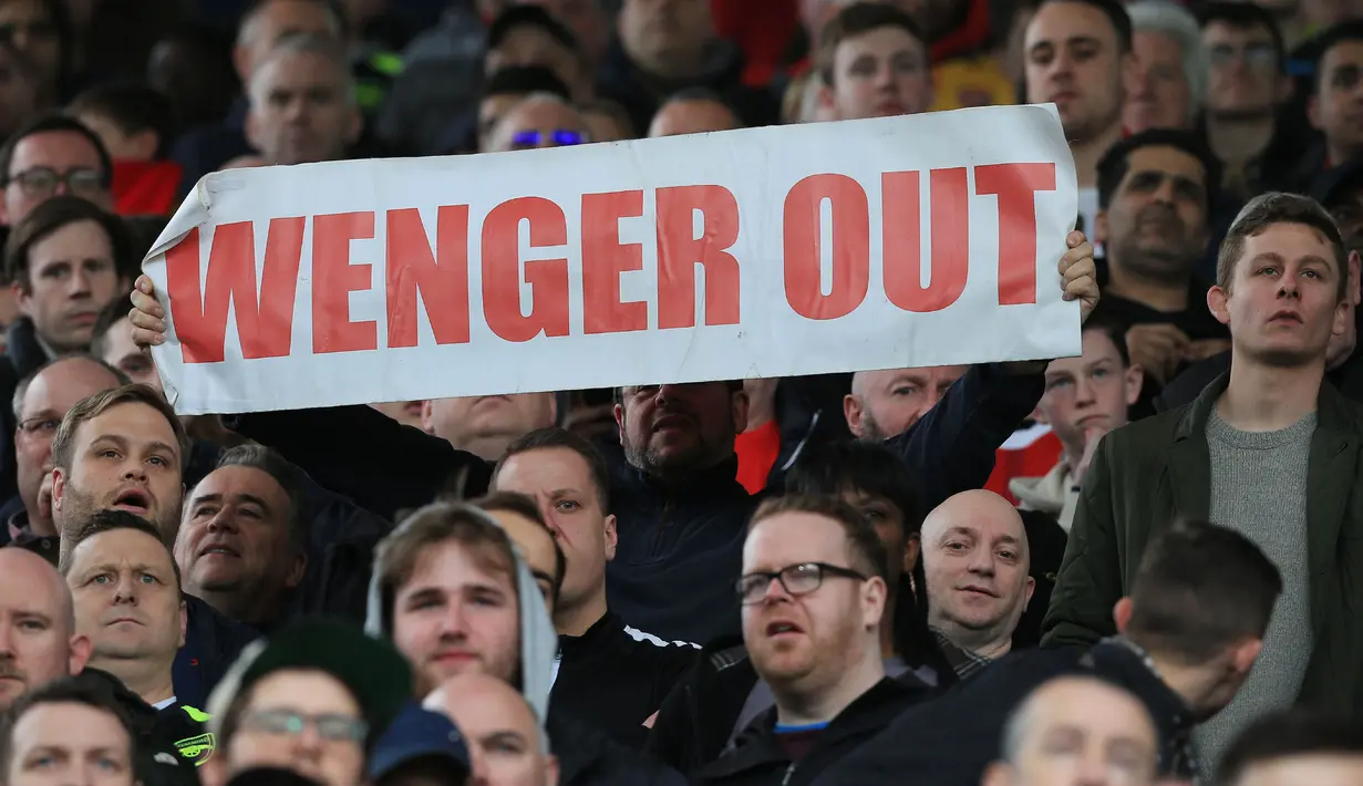 Suporter Arsenal mengankat tulisan "Wenger Out" saat menyaksikan pertandingan antara West Bromwich Albion melawan Arsenal pada lanjutan Premier League. Mereka mengungkapkan kekecewanya terhadap Pelatih Arsenal, Arsene Wenger. (AFP/Lindsey Parnaby).