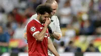 Pemain depan Liverpool Mohamed Salah meninggalkan lapangan sambil menangis usai cedera saat melawan Real Madrid dalam pertandingan final Liga Champions di Stadion NSK Olimpiyskiy, Ukraina (26/5). (AP / Matthias Schrader)