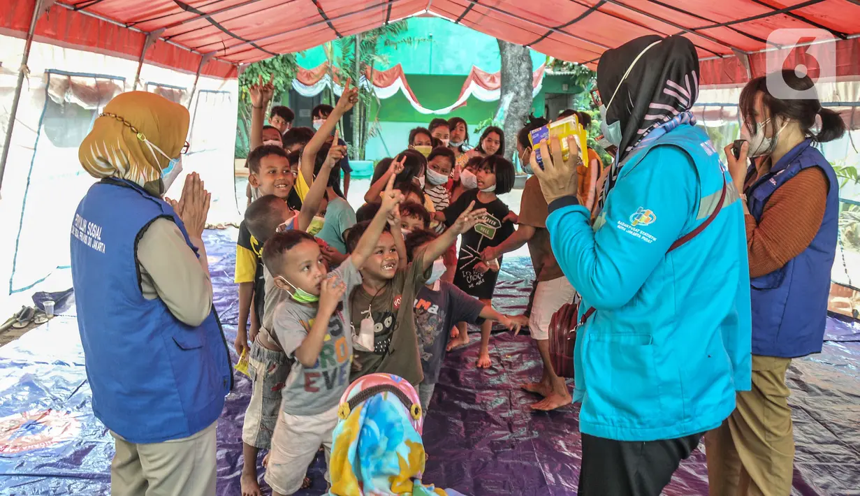 Anak-anak mendapatkan makanan usai mendengarkan dongeng di tenda pengungsian di SDN 09 Kebon Kosong, Kemayoran, Jakarta, Selasa (31/8/2021). Kegiatan bertujuan menghilangkan trauma atau rasa takut serta kebosanan anak-anak korban kebakaran saat berada di pengungsian. (merdeka.com/Iqbal S. Nugroho)