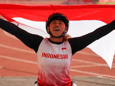 Atlet balap kursi roda Maria Goreti melakukan selebrasi usai memenangi final balap kursi roda 400 meter putri 11th ASEAN Para Games 2022 di Stadion Manahan, Solo, Jawa Tengah, kamis (4/8/2022). Maria Goreti meraih medali emas pada final tersebut. (INASPOC/Feri Setiawan)