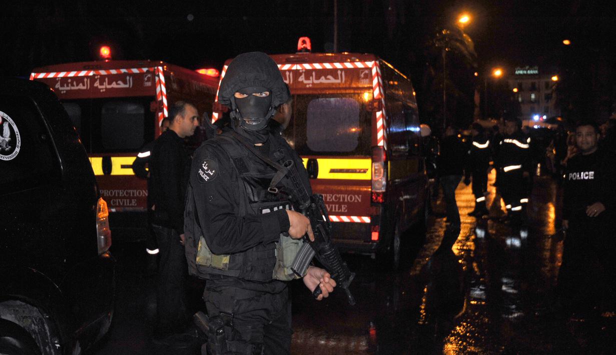 Petugas memblokir jalan menuju lokasi ledakan di sebuah bus yang mengangkut pengawal Presiden Tunisia di Tunis, Selasa (24/11). Insiden yang diduga akibat serangan bom bunuh diri itu menewaskan 12 orang dan melukai 16 lainnya. (AFP PHOTO/Fethi Belaid)