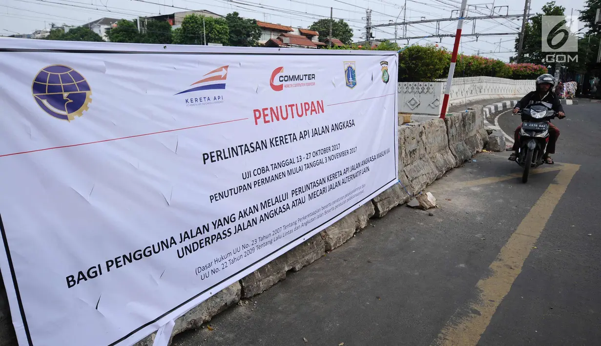 Pengendara melintasi sisi spanduk sosialisasi penutupan perlintasan kereta di Jalan Angkasa, Jakarta, Minggu (15/10). Penutupan secara permanen perlintasan KA di Jalan Angkasa akan dilakukan pada 3 November mendatang. (Liputan6.com/Helmi Fithriansyah)
