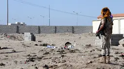 Seorang tentara mengamati lokasi bom bunuh diri di sebuah pangkalan militer kota Aden, Yaman, Minggu (18/12). Bom bunuh diri itu meledak saat para tentara mengantre pembagian gaji di dekat pangkalan militer di distrik Khor Maksar. (SALEH AL-OBEIDI/AFP)