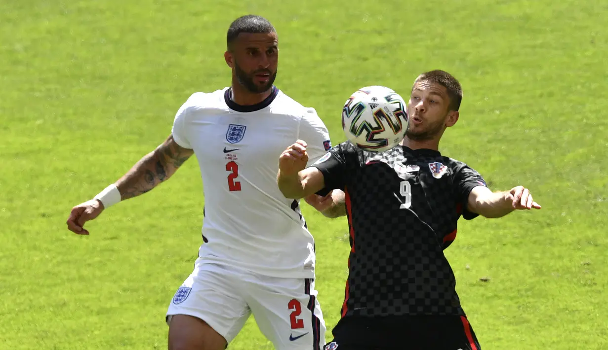 Penyerang Kroasia, Andrej Kramaric mengontrol bola dari kawalan bek Inggris, Kyle Walker pada pertandingan grup D Euro 2020 di stadion Wembley di London, Minggu (13/6/2021). Inggris menang tipis atas Kroasia dengan skor 1-0. (AP Photo/Justin Tallis, Pool )
