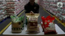 Pekerja menunjukkan kemasan beras premium di Komplek Pergudangan Pasar Induk Beras Cipinang, Jakarta Timur, Rabu (21/2/2024). (Liputan6.com/Herman Zakharia)