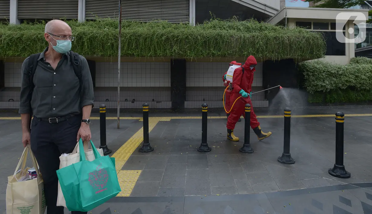 Petugas pemadam kebakaran (Damkar) melakukan penyemprotan disinfektan di sepanjang jalan Jenderal Sudirman-MH Thamrin, Jakarta, Sabtu (20/6/2020). Penyemprotan dalam rangka kembali diadakannya Car free day di Jalan Sudirman-Thamrin pada Minggu, 21 Juni esok. (merdeka.com/Imam Buhori)