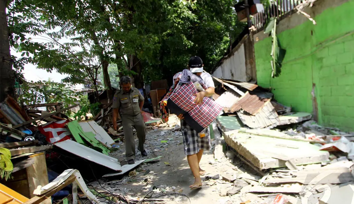 Seorang warga menyelamatkan barang-barangnya saat terjadi pembongkaran oleh Satpol PP, Jakarta, Rabu (7/5/2014) (Liputan6.com/Johan Tallo).