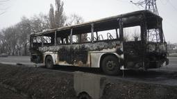Sebuah bus, yang terbakar saat bentrokan, terlihat di sebuah jalan di Almaty, Kazakhstan, Minggu (9/1/2022). Kantor Presiden Kassym-Jomart Tokayev mengatakan hari Minggu bahwa ketertiban telah diatur di negara itu. (Vladimir Tretyakov/NUR.KZ via AP)