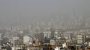 Badai pasir melanda gedung-gedung di utara ibu kota Iran, Teheran pada 17 Mei 2022. Kantor-kantor pemerintah, serta sekolah dan universitas diumumkan ditutup di banyak provinsi di Iran karena kondisi "cuaca tidak sehat" dan badai pasir yang menyelimuti, menurut laporan media pemerintah. (AFP)