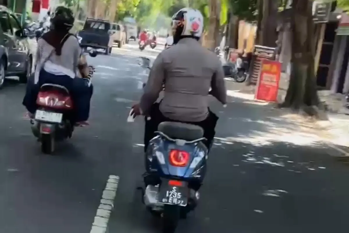 Polisi naik motor sambil merokok