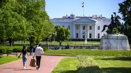 Turis dan warga mengunjungi Lafayette Square dekat Gedung Putih di Washington, DC, pada Selasa (10/5/2021). Lafayette Square dibuka kembali untuk pejalan kaki hampir setahun setelah daerah itu dipagari ketika demonstrasi semakin besar sebagai tanggapan atas kematian George Floyd. (Eric BARADAT/AFP)