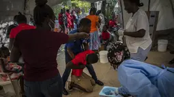 Seorang pemuda yang menderita gejala kolera ditolong setibanya di sebuah klinik yang dikelola oleh Doctors Without Borders di Port-au-Prince, Haiti, Kamis, 27 Oktober 2022. Untuk pertama kalinya dalam tiga tahun, orang-orang di Haiti telah sekarat karena kolera, meningkatkan kekhawatiran tentang skenario yang berpotensi menyebar cepat dan menghidupkan kembali ingatan tentang epidemi yang menewaskan hampir 10.000 orang satu dekade lalu. (AP/Ramon Espinosa)