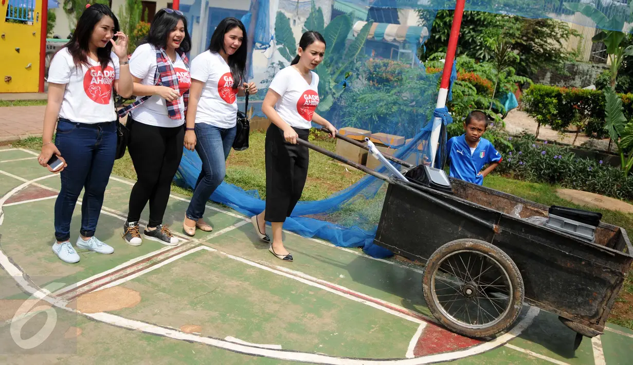 Relawan dari Gerakan Aksi Srikandi Coblos Ahok (Gadis Ahok) saat mendatangi kawasan Cipete, Jakarta Selatan, Senin (26/12). Mereka juga ikut membersihkan lingkungan sekitar di kawasan tersebut. (Liputan6.com/Gempur M Surya)