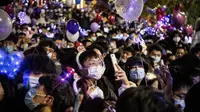 Orang-orang menghadiri  hitung mundur di Wuhan, provinsi Hubei, China (1/1/2021). Beberapa warga Wuhan mengatakan mereka berhati-hati, tetapi sebagaian tidak khawatir tertular Covid-19. (AFP/Noel Celis)