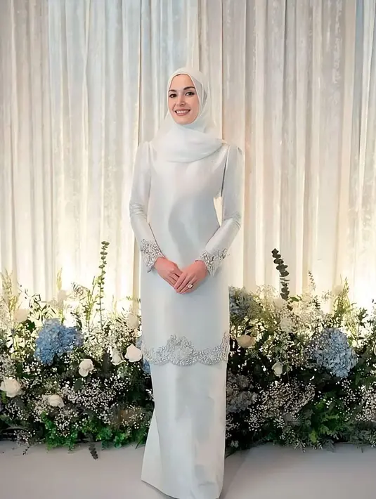 Baju kurung satin warna putih dengan aksen bordiran di tepian juga tak kalah elegan. Padukan dengan hijab warna senada. [@anisharsnh/@mateen_anishh/@tehfirdaus]