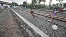 Anak-anak saat bermain di dekat rel kereta api di kawasan Bahari Ujung, Tanjung Priok, Jakarta Utara, Selasa (24/5/2022). Minimnya fasilitas dan ruang terbuka hijau di kawasan tersebut menyebabkan anak-anak setempat memilih bermain di sekitar perlintasan kereta api yang dapat membahayakan keselamatan mereka. (merdeka.com/Iqbal S Nugroho)