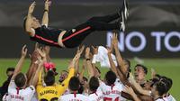 Pemain Sevilla mengangkat sang pelatih, Julen Lopetegui, usai mengalahkan Inter Milan pada laga final Liga Europa 2019/2020 di Stadion RheinEenergie, Sabtu (22/8/2020) dini hari WIB. Sevilla menang 3-2 atas Inter Milan. (AFP/Friedemann Vogel/pool)