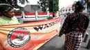 Petugas Panwas Kota Yogyakarta membentangkan spanduk saat sosialisasi di kawasan Titik Nol Kilometer Yogyakarta, Senin (1/8). Kegiatan tersebut untuk mensosialisasikan pelaksanaan pilkada bebas politik uang pada 2017 mendatang. (Liputan6.com/Boy Harjanto)
