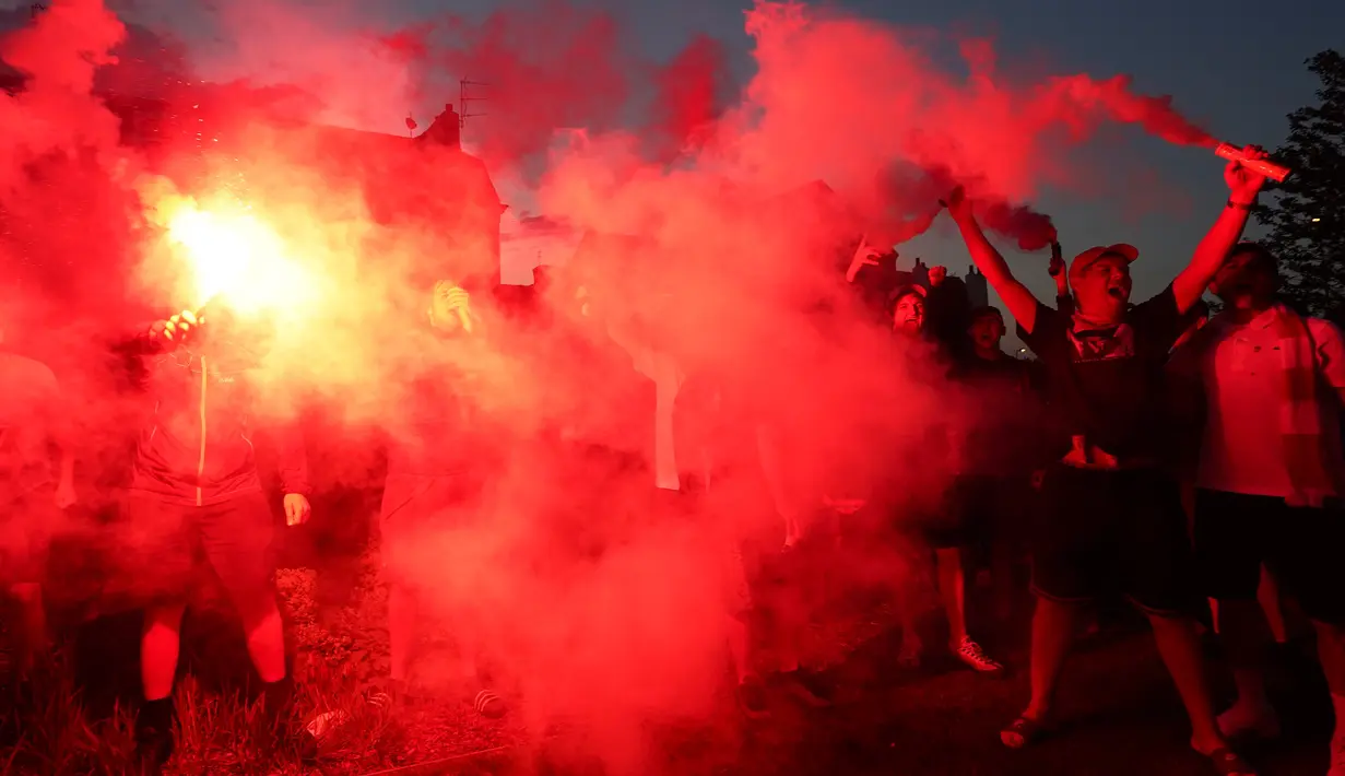 Pendukung Liverpool merayakan gelar juara Liga Premier di luar Stadion Anfield, Kamis (25/6/2020). Trofi juara Liga Primer musim 2019-2020 tersebut dimenangkan Liverpool setelah Manchester City takluk 1-2 dari Chelsea di Stamford Bridge. (AP Photo/Jon Super)