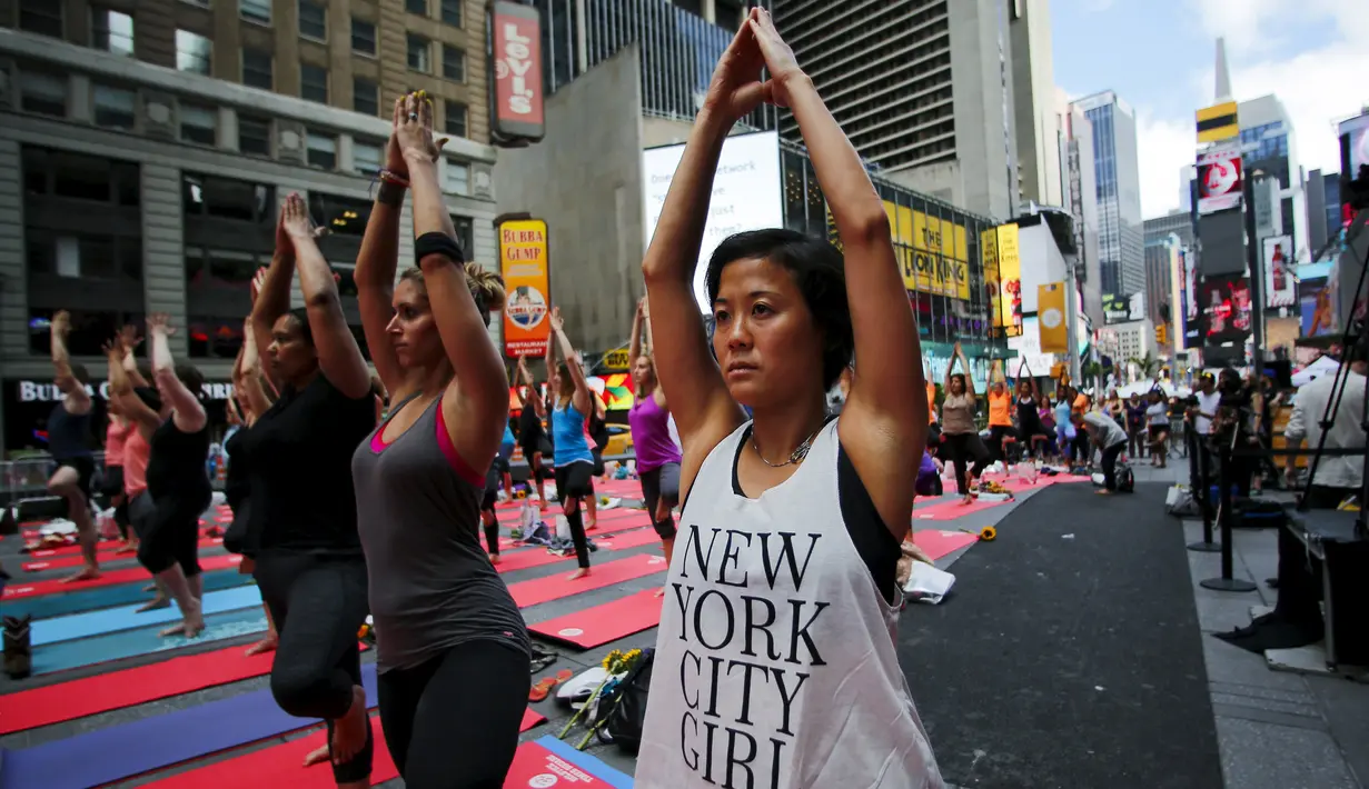 Warga saat berlatih yoga di tengah jalan saat perayaan Summer Solstice di Hari Yoga Internasional di Times Square, New York, Minggu (21/6/2015). (REUTERS/Eduardo Munoz)