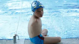 Ismail Zulfic duduk dipinggir kolam saat beristirat latihan renang di kolam renang Olimpiade di Sarajevo, Bosnia (8/6). Ismail terlahir dengan cacat bawaan, ia tidak memiliki lengan dan tangan. (AP Photo/Amel Emric)