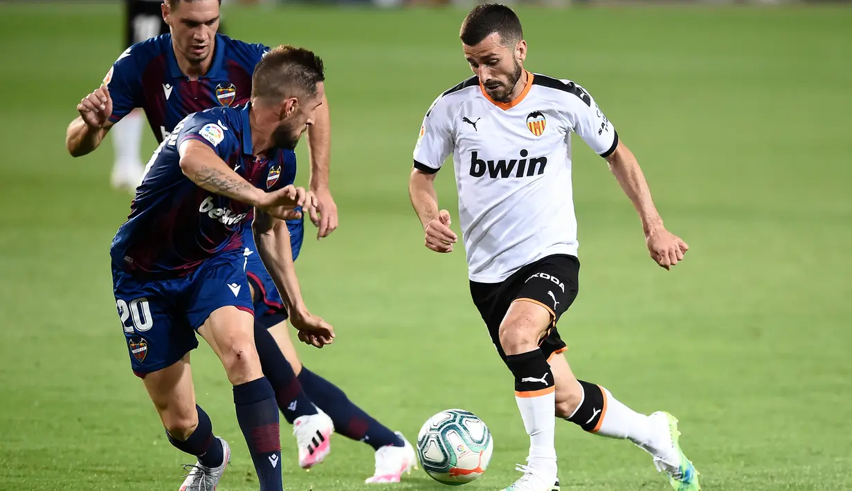 Gelandang Valencia, Nikola Vukcevic, berebut bola dengan bek Levante, Jose Gaya, pada laga pekan ke-28 Liga Spanyol di Stadion Mestalla, Sabtu (13/6/2020) dini hari WIB. Valencia bermain imbang 1-1 atas Levante. (AFP/Jose Jordan)