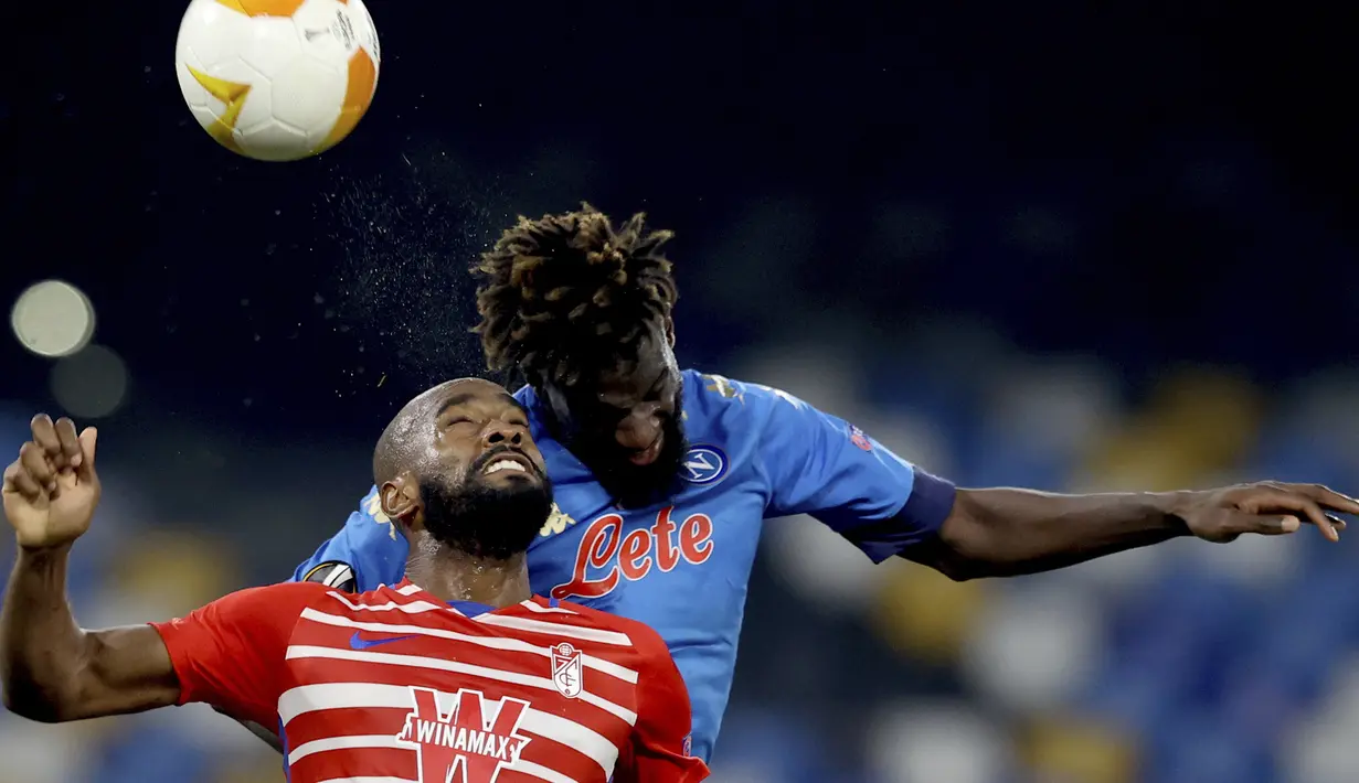 Gelandang Napoli, Tiemoue Bakayoko (atas) berduel udara dengan gelandang Granada, Yangel Herrera dalam laga leg kedua babak 32 Besar Liga Europa 2020/21 di Diego Armando Maradona Stadium, Kamis (25/2/2021). Napoli menang 2-1 atas Granada. (LaPresse via AP/Alessandro Garofalo)