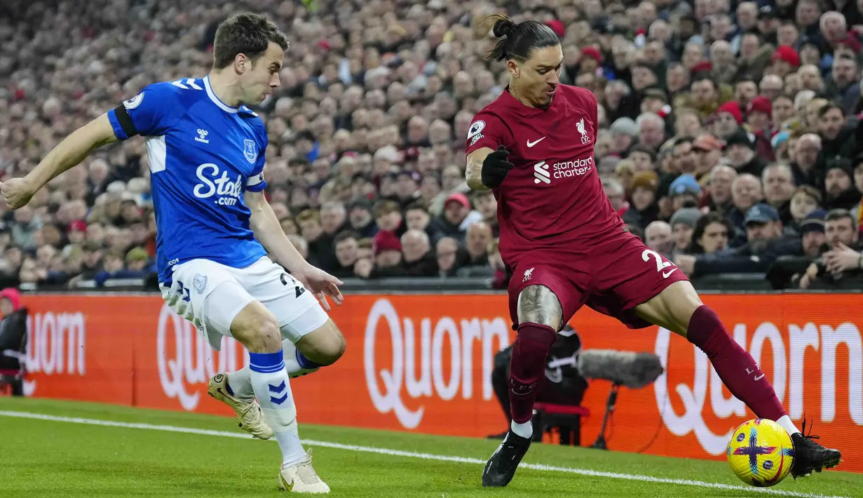 Pemain Liverpool, Darwin Nunez, berusaha melewati pemain Everton, Seamus Coleman, pada laga Liga Inggris di Stadion Anfield, Selasa (14/2/2023). (AP Photo/Jon Super)
