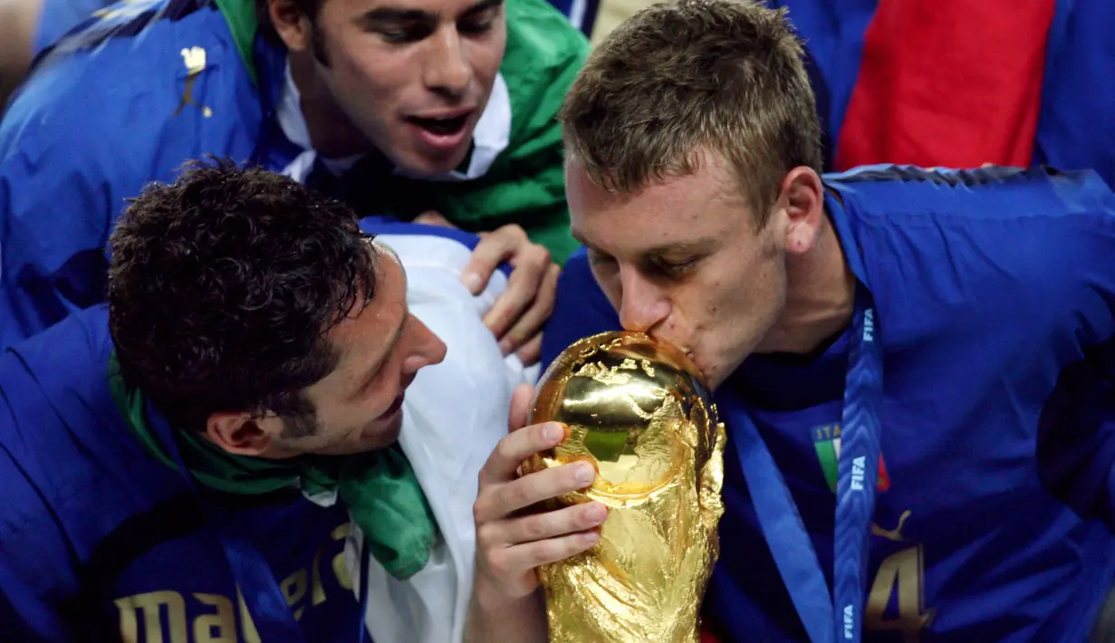 Daniele De Rossi (kanan) saat mencium trofi Piala DUnia 2006. De Rossi memulai karir di timnas Italia pada 2004 dan mencetak 13 gol hingga pensiun pada 2017. (AFP/Odd Andersen)