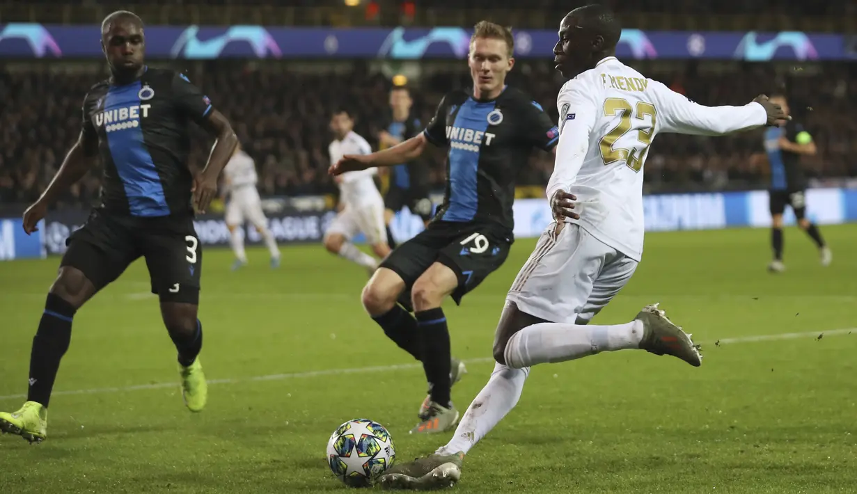Bek Real Madrid, Ferland Mendy berusaha mengumpan bola dari kawalan pemain Club Brugge, Thibault Vlietinck pada pertandingan Grup A Liga Champions di stadion Jan Breydel di Bruges, Belgia (11/12/2019). Real Madrid menang 3-1 atas Club Brugge. (AP Photo/Francisco Seco)