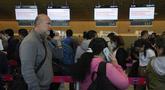 Para penumpang Ultra Air mengantre di konter maskapai penerbangan Avianca untuk terbang siaga secara gratis setelah maskapai penerbangan mereka, Ultra Air, menangguhkan operasinya, di Bandara Internasional El Dorado di Bogota, Kolombia, Kamis (30/3/2023). (AP Photo/Fernando Vergara)