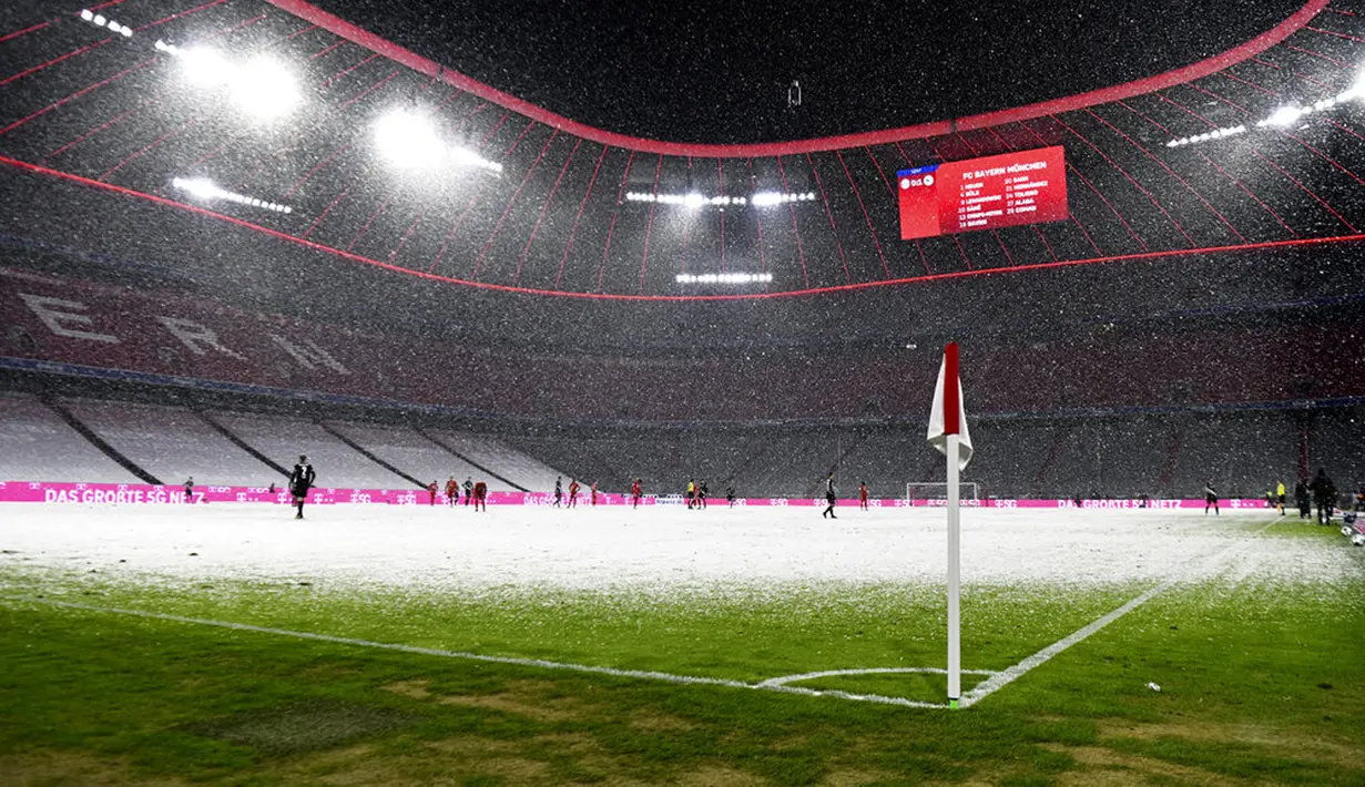 Pemandangan saat hujan salju mewarnai pertandingan Bundesliga antara Bayern Munchen dan Arminia Bielefeld di Allianz Arena, Munich, Jerman, Senin (15/2/2021). Laga berakhir dengan skor 3-3. (AP Photo/Andreas Schaad, Pool)