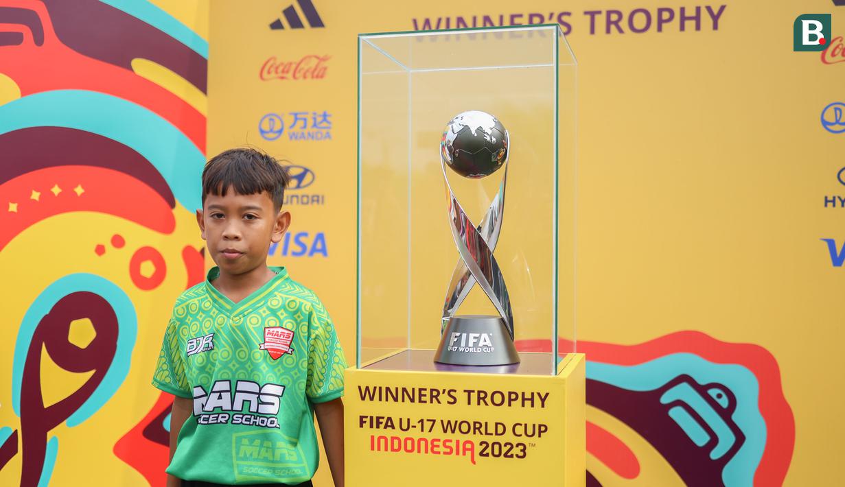 Warga Solo juga bisa berfoto bersama trofi Piala Dunia U-17 yang dipamerkan di Pura Mangkunegaraan, depan Gedung Kavallerie-Artillerie, Solo, Minggu (5/11/2023). (Bola.com/Radifa Arsa)