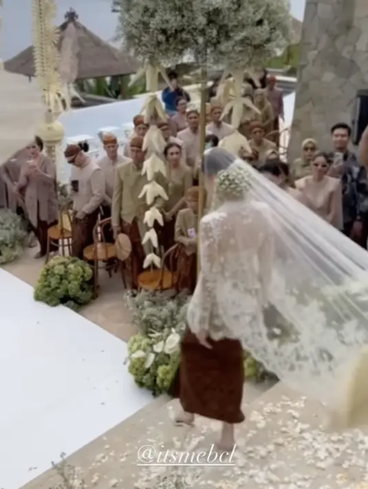 Kesan dramatis semakin terlihat dengan aksen veil yang menjuntai. Membuat ia kian cantik saat berjalan menuju pelaminan. (Instagram/bcltiko)