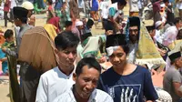 Umat muslim usai melaksanakan salat Jumat di sebuah ladang di dekat tempat penampungan sementara setelah gempa di Pemenang, Lombok (10/8). Jumlah Korban tewas akibat gempa dahsyat 6,9 SR di pulau Lombok melonjak di atas 300 orang. (AFP Photo/Adek Berry)