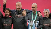 Josep Guardiola berpose dengan trofi juara Carabao Cup, Senin (26/04/2021) dini hari WIB. (CARL RECINE / POOL / AFP)