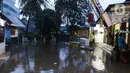 Kondisi banjir yang melanda Jalan Pondok Karya, Jakarta, Rabu (4/1/2023). Hujan deras yang terjadi pada Rabu sore membuat Kali Mampang meluap hingga menyebabkan banjir di kawasan tersebut dengan ketinggian bervariasi mulai dari 40 hingga 60 cm. (Liputan6.com/Herman Zakharia)